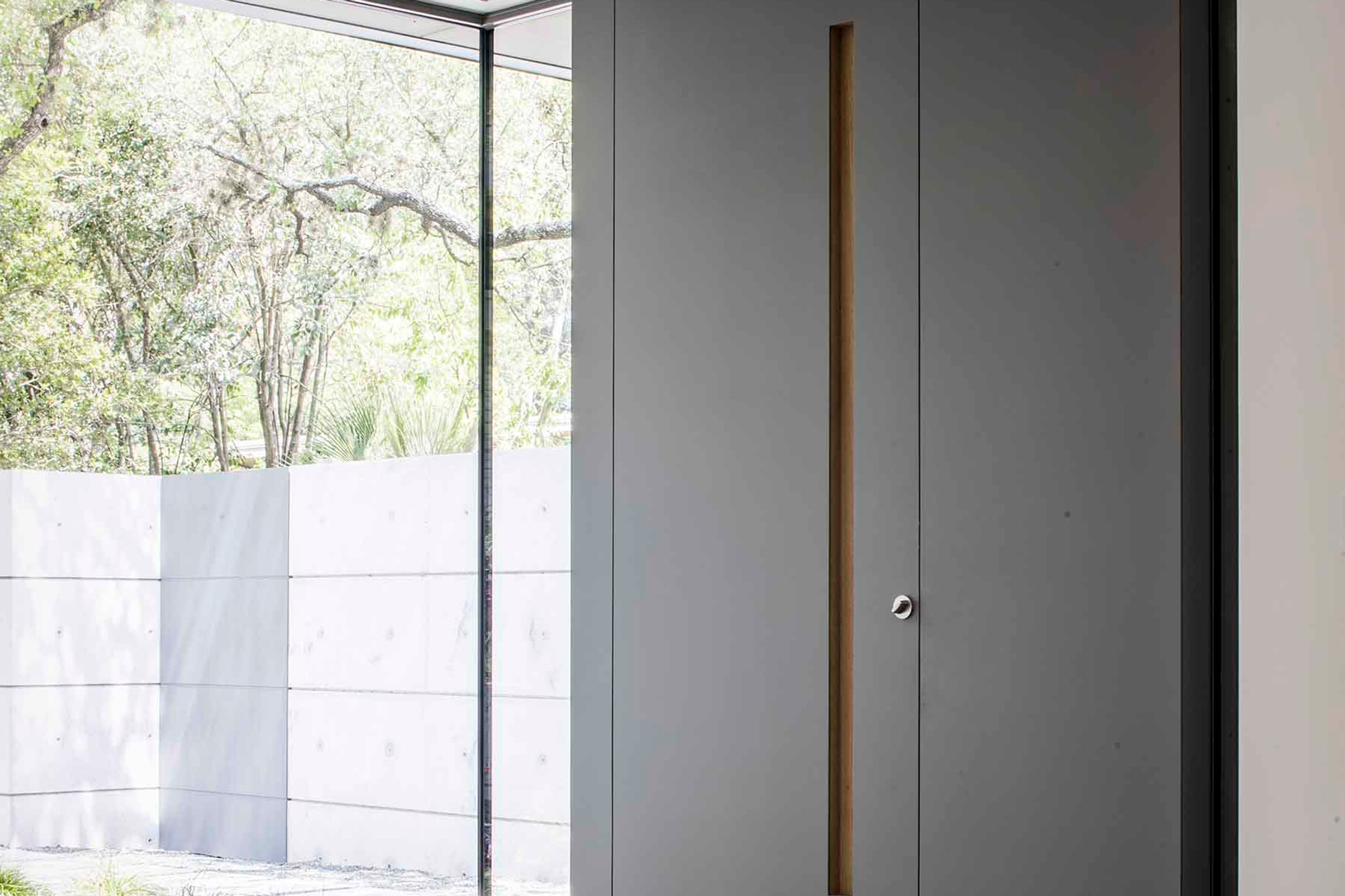 Front facade with form board concrete walls and standing seam metal roof