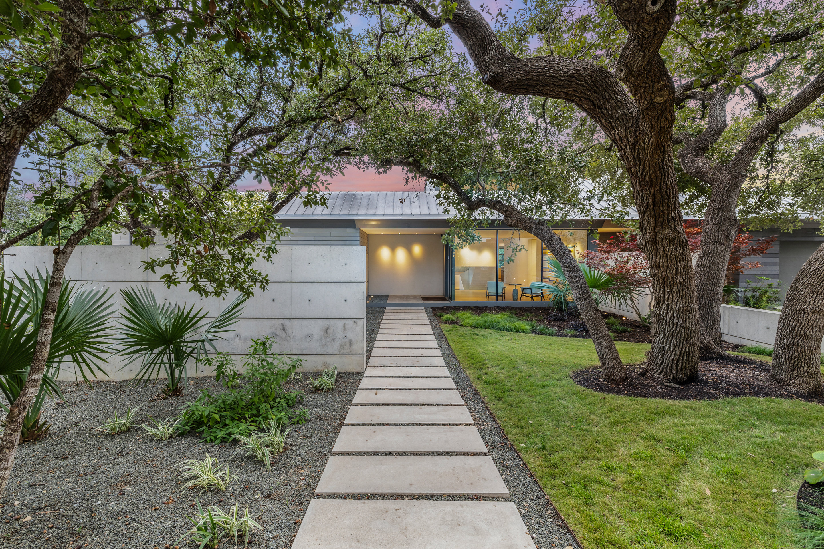 South facade with cantilevered standing seam metal roof at dusk