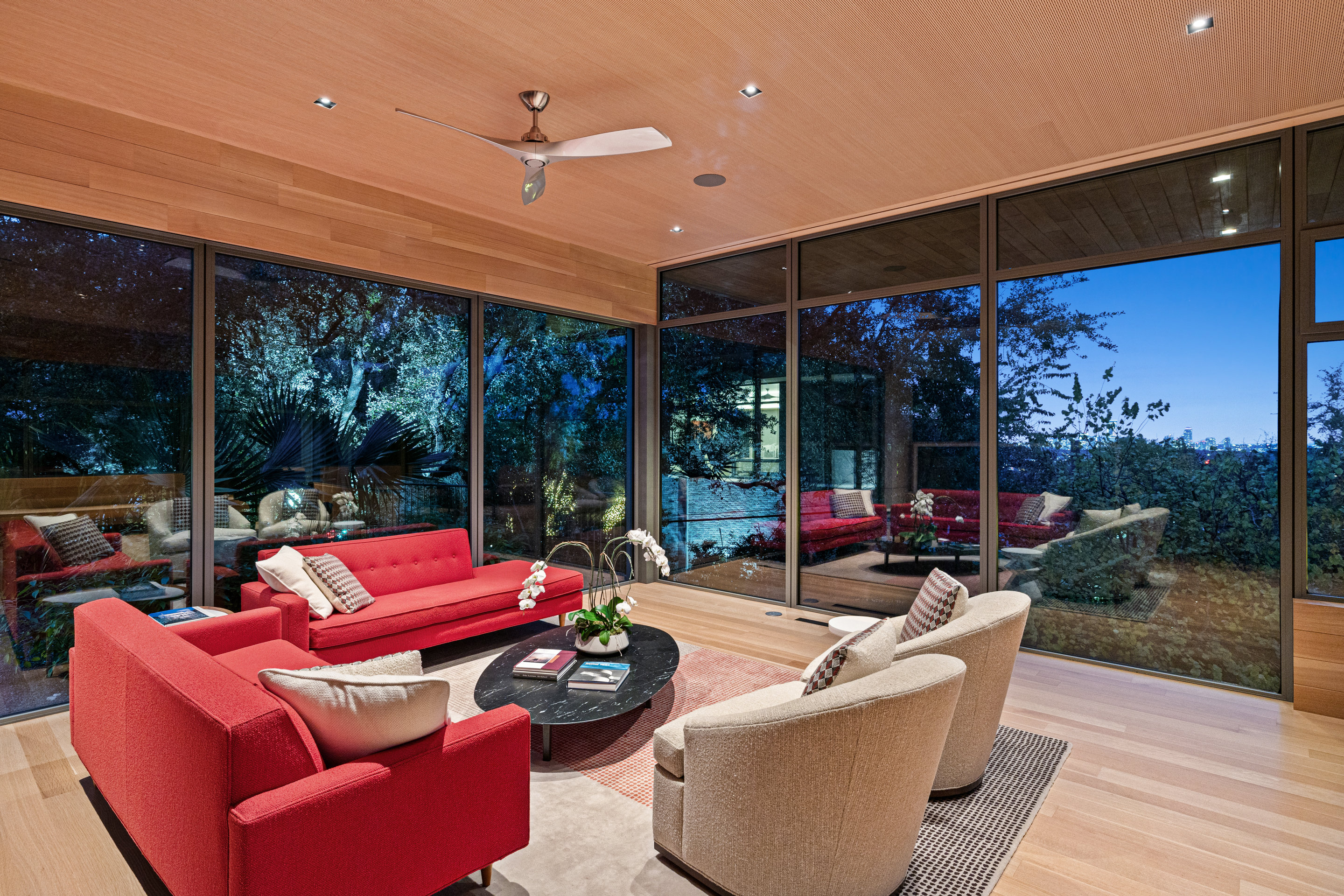 Living room with floor-to-ceiling windows framing tree canopy views