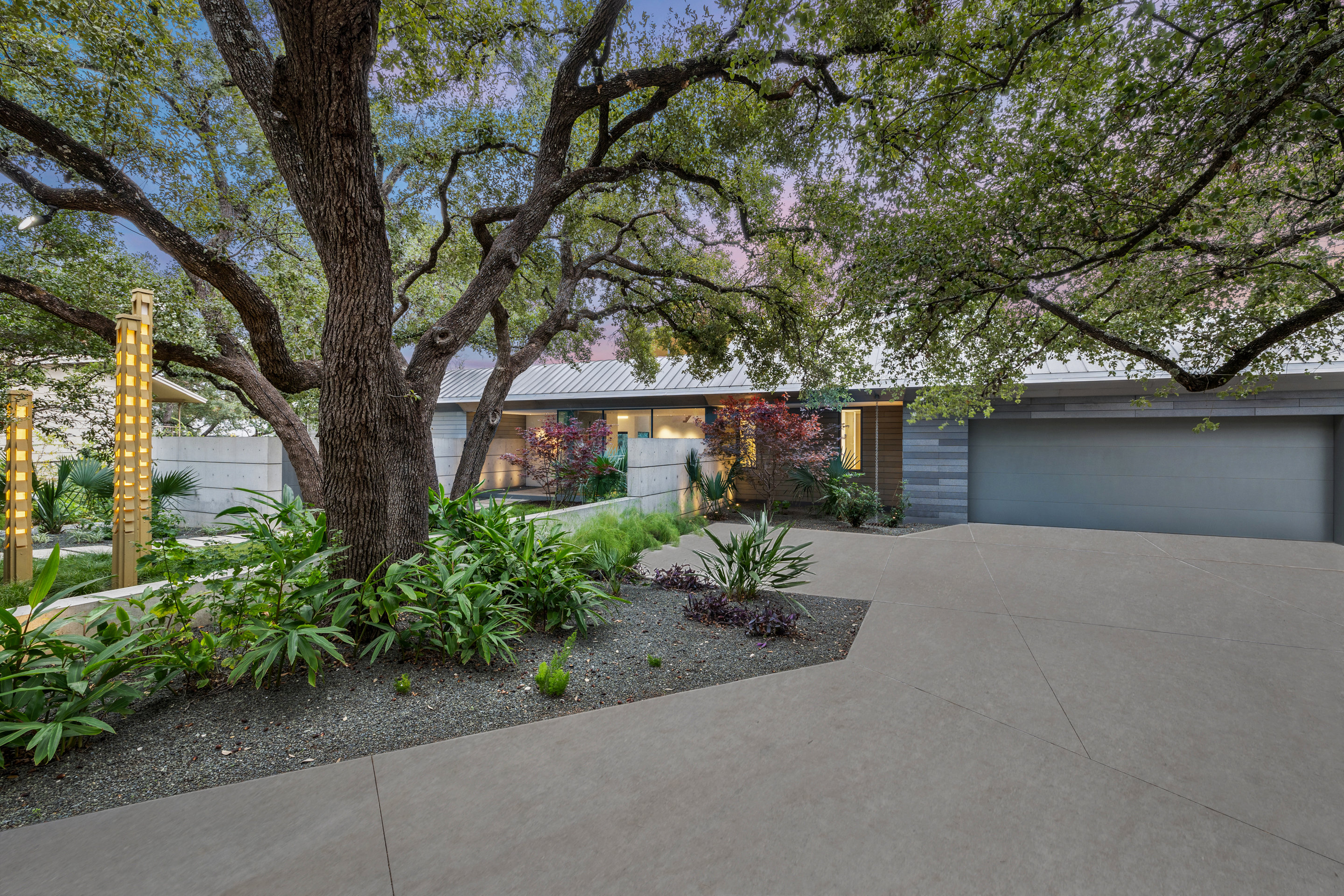Driveway approach with illuminated entry lanterns and two-car garage