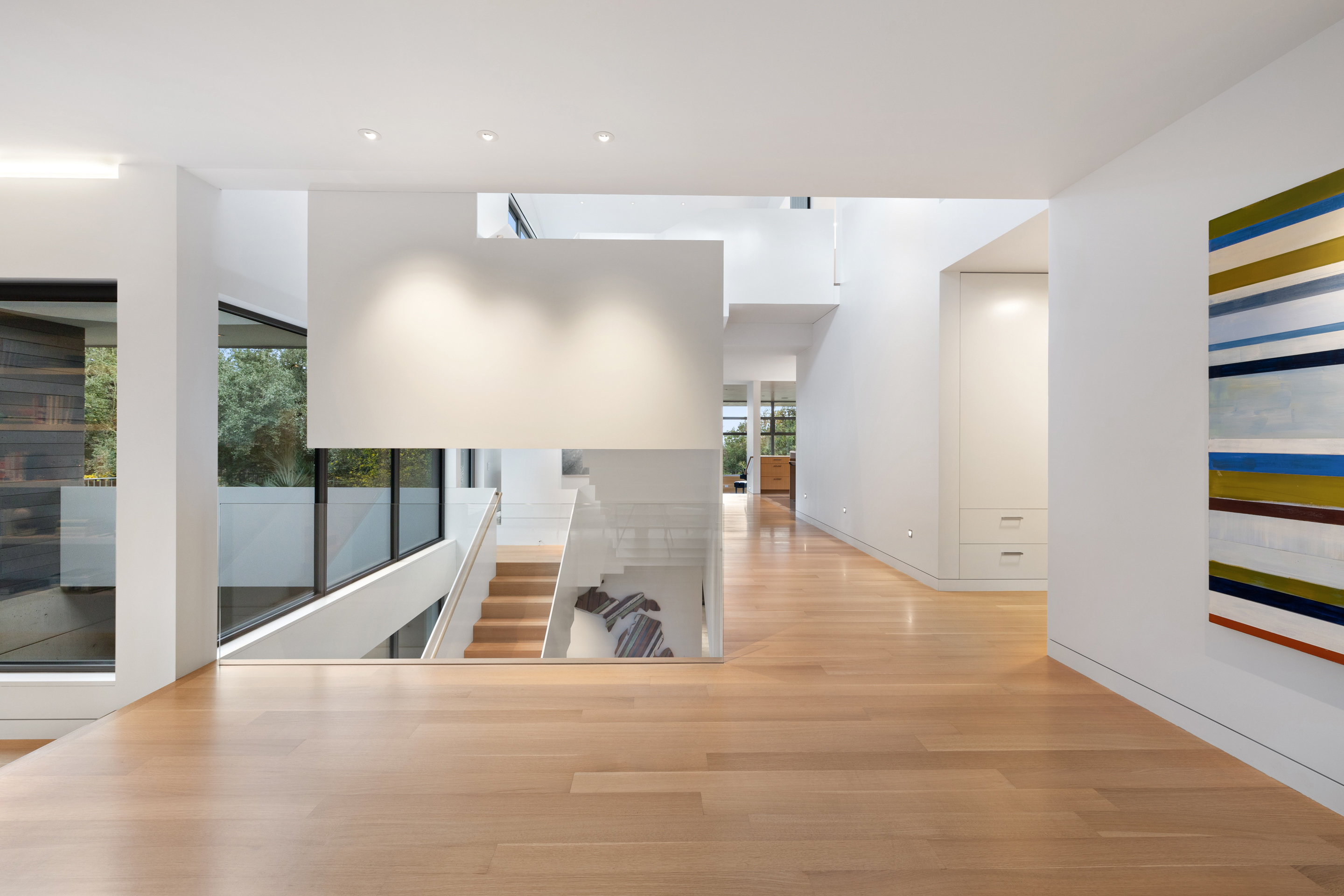 Lower staircase landing with exposed concrete and in-ground lighting