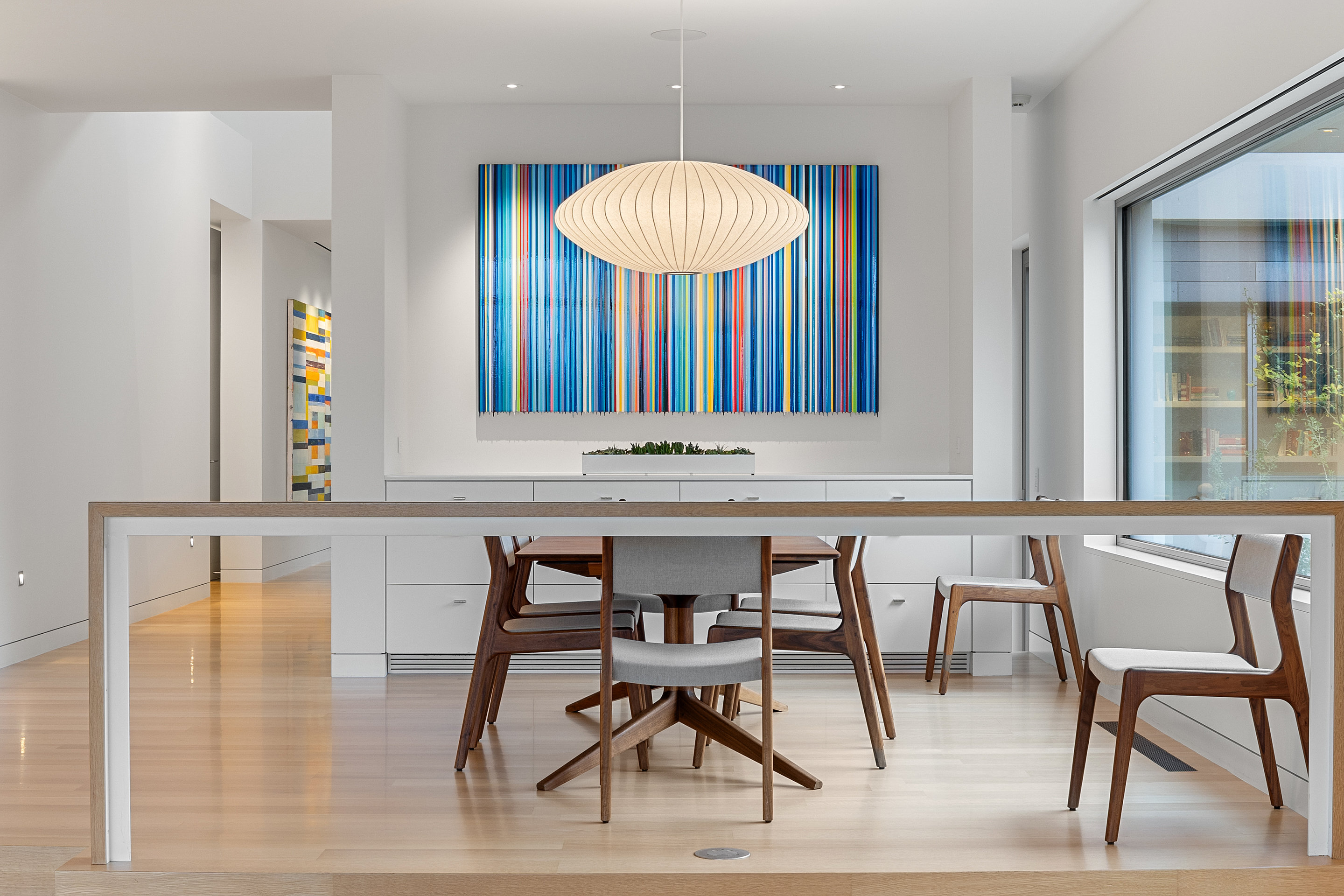 Formal dining with George Nelson bubble pendant and contemporary art