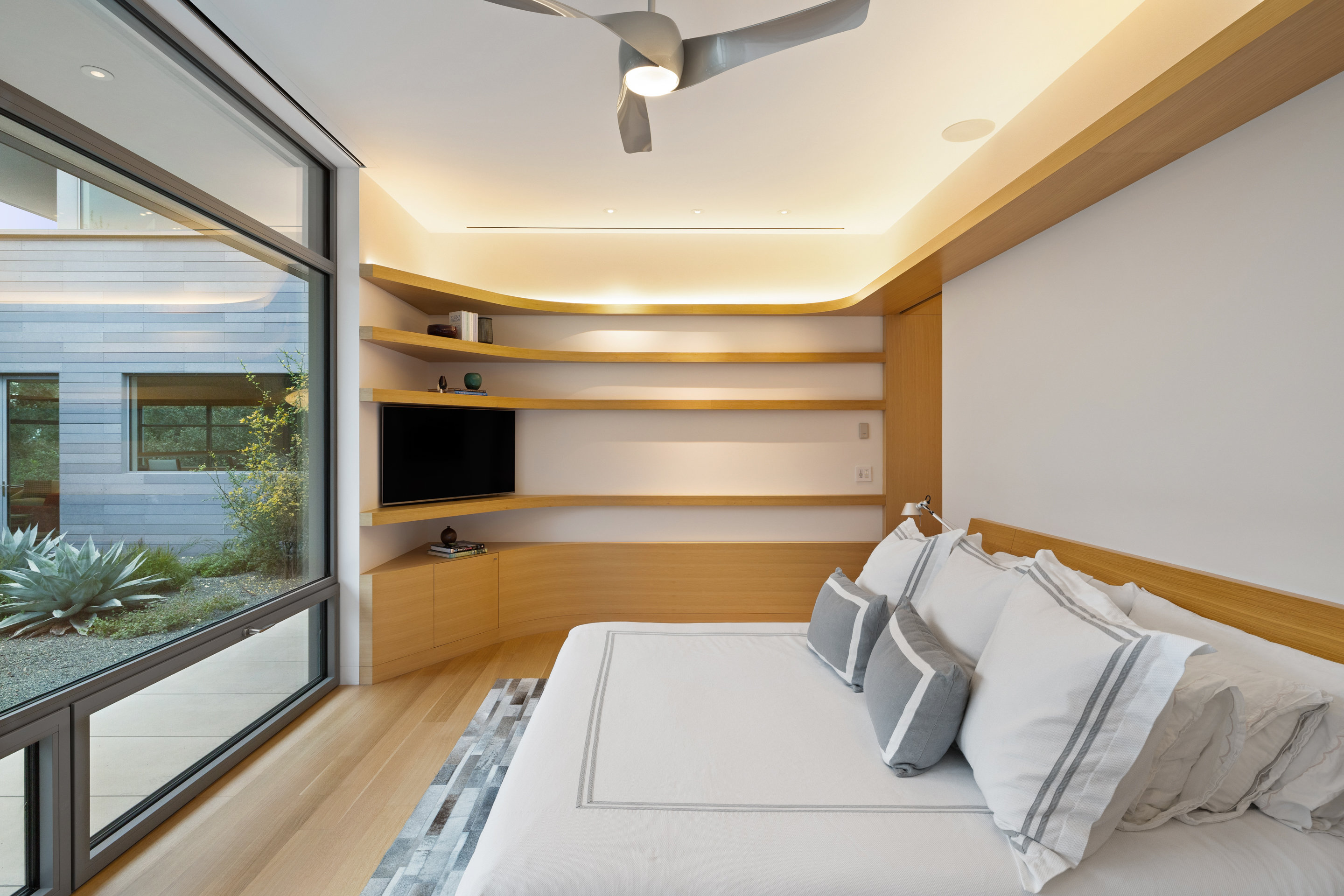 Primary bedroom with white oak millwork and cove lighting