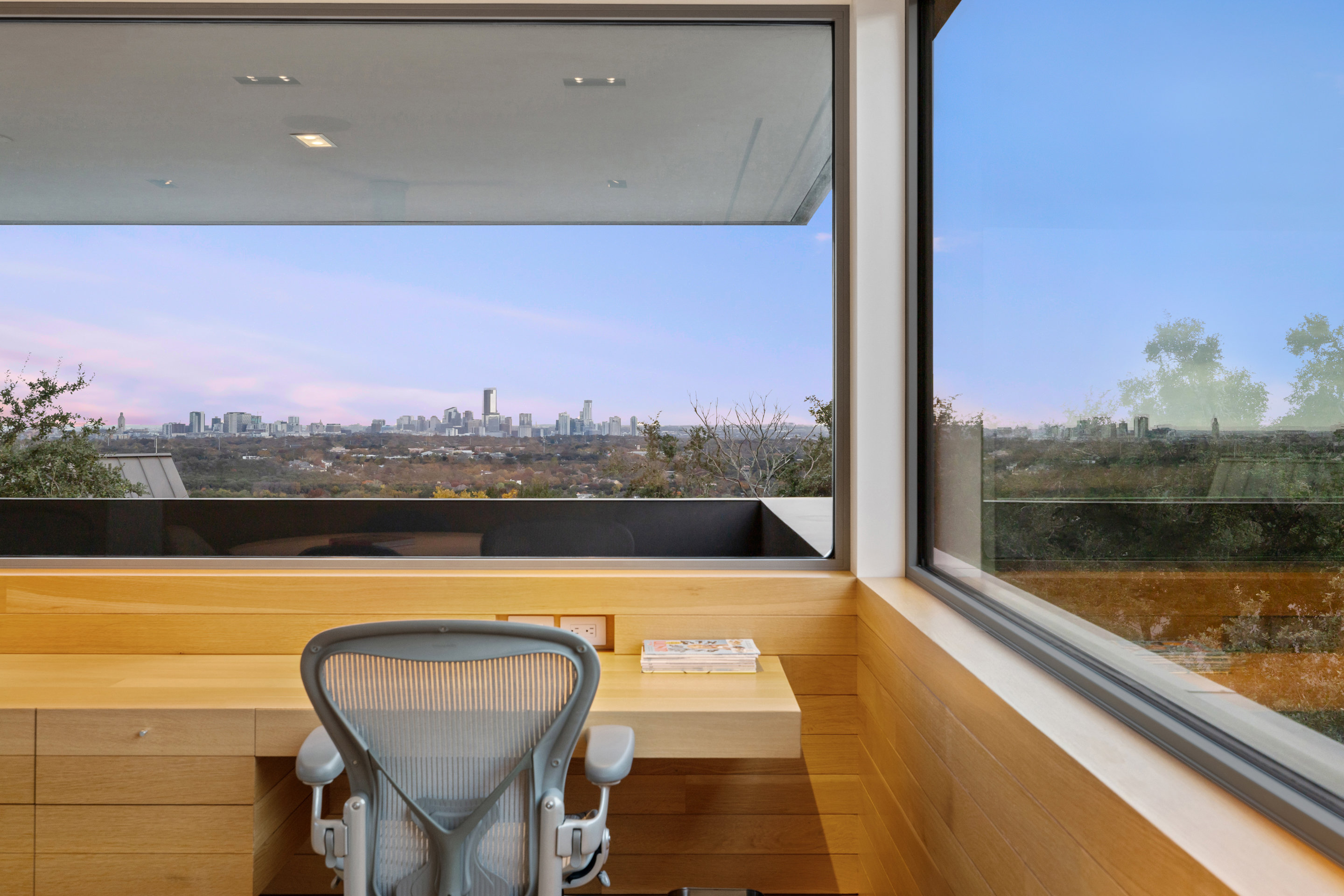 Upper office with Saarinen tulip table, built-in desk, and skyline panorama
