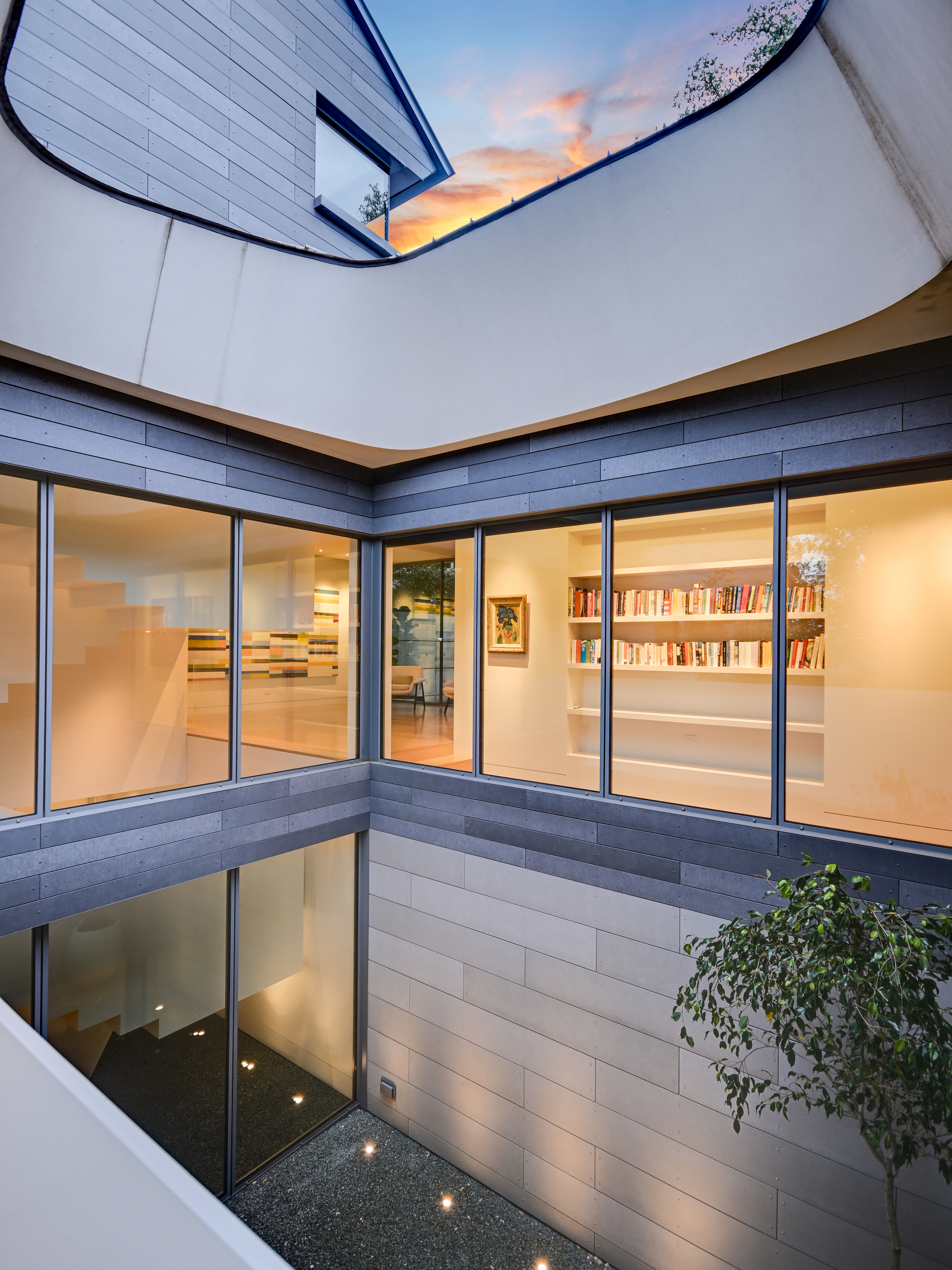 Two-story atrium with Oculus roof light open to sunset sky