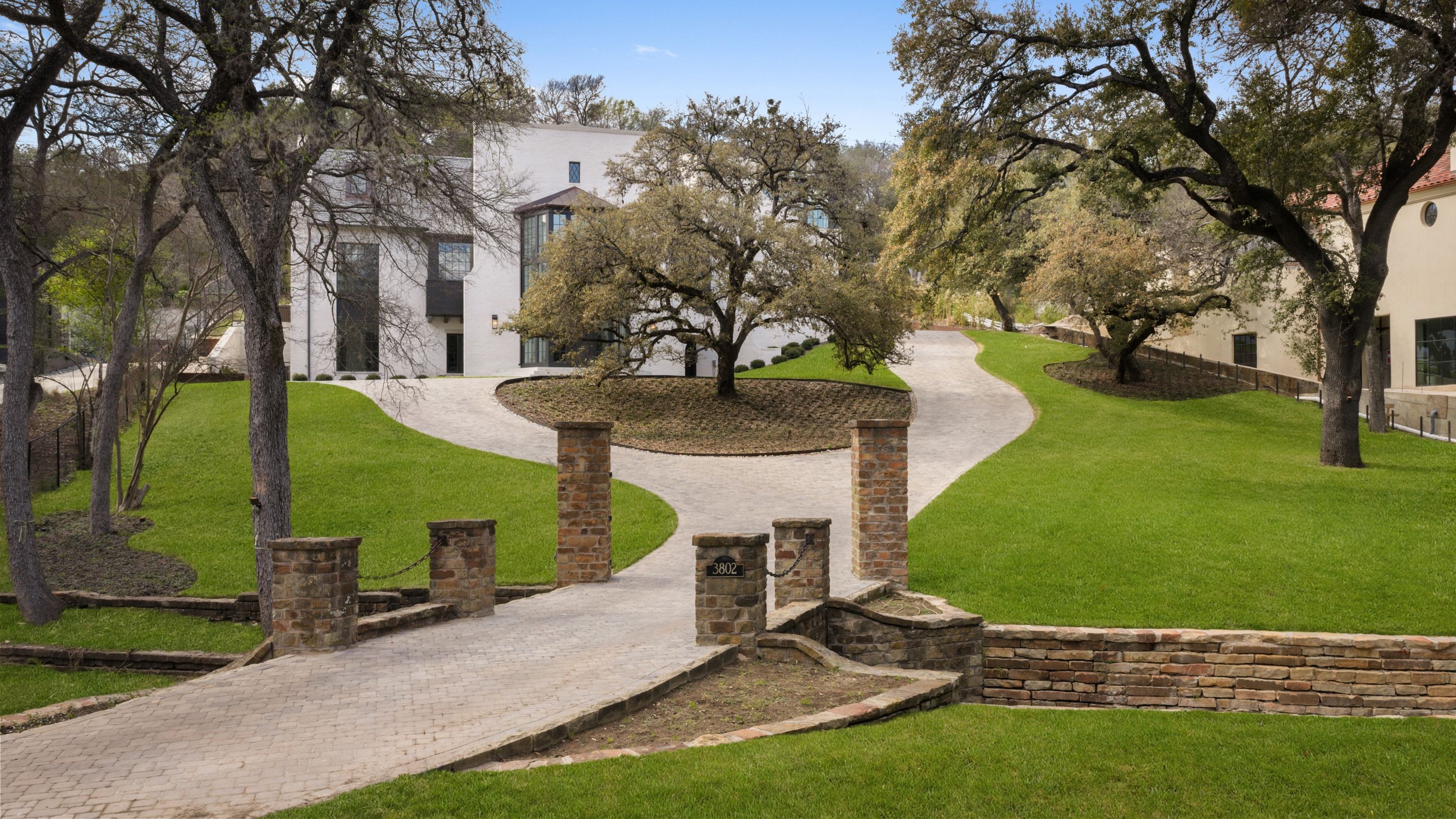 Wide aerial showing full estate and oak canopy