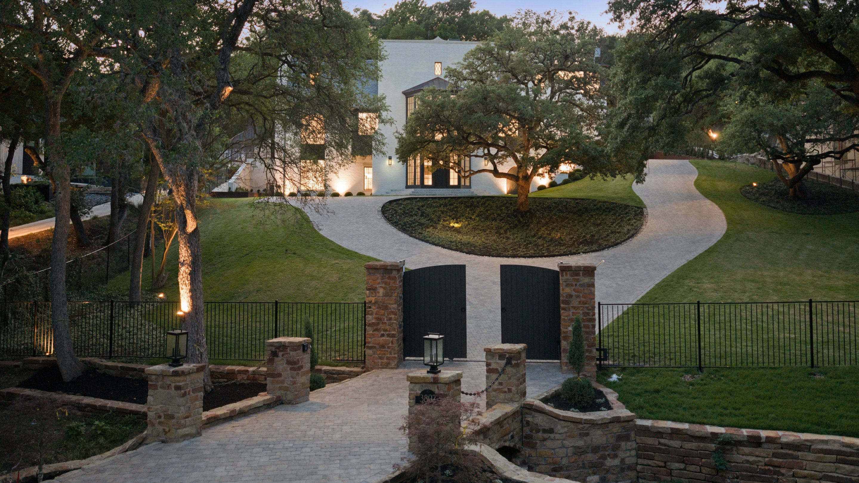 3802 Balcones Drive gated drive aerial dusk
