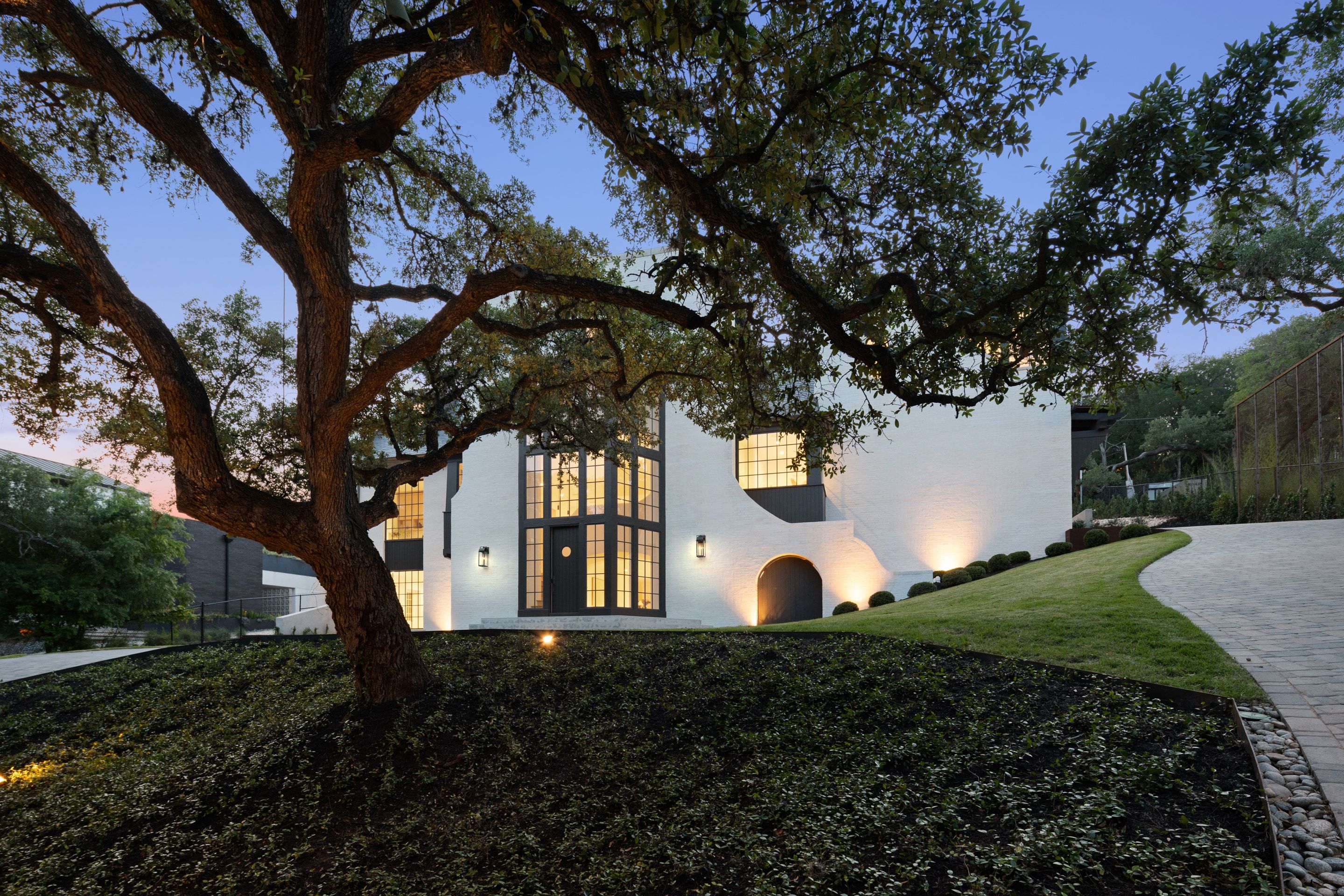 3802 Balcones Drive front oak canopy dusk