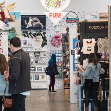 Artwork and handmade goods at an indoor market.