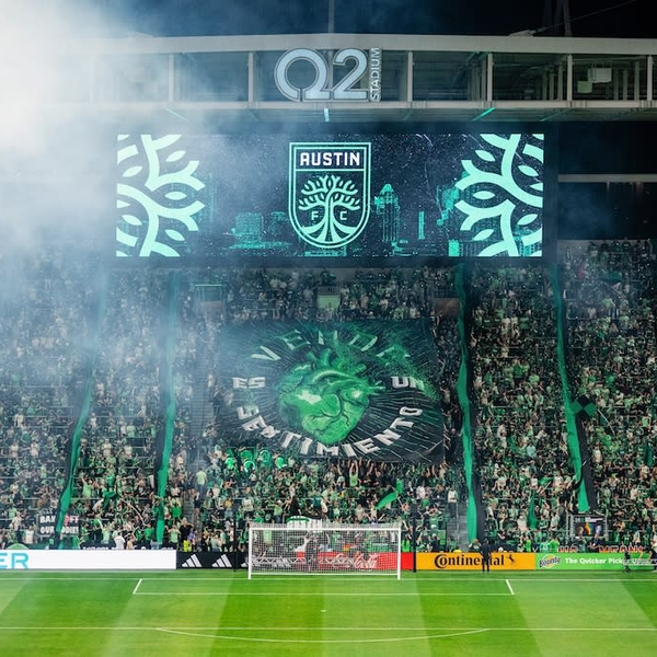 Supporters and green smoke at Q2 Stadium.