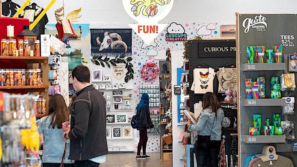Visitors browsing an indoor art market.