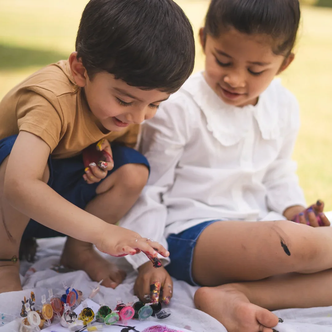 Two children working with colorful craft materials.