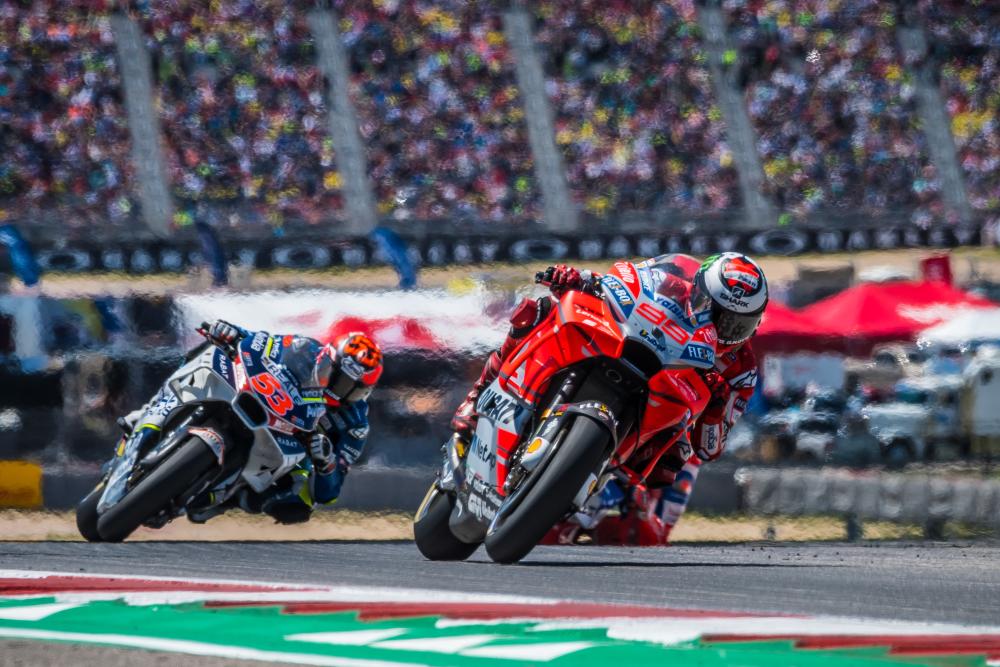 Motorcycle racers leaning into a turn.
