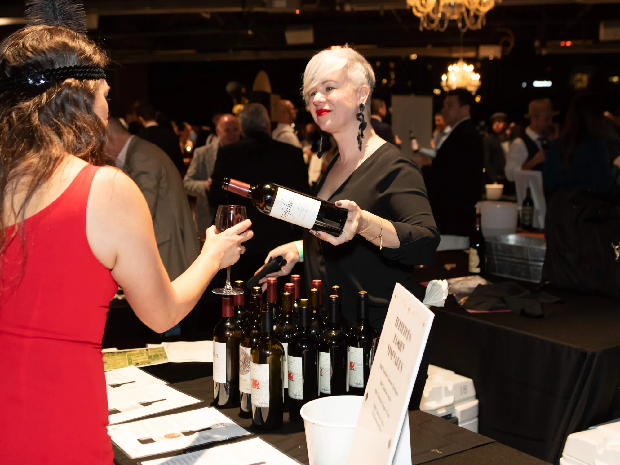 Guests tasting wine at an indoor event.