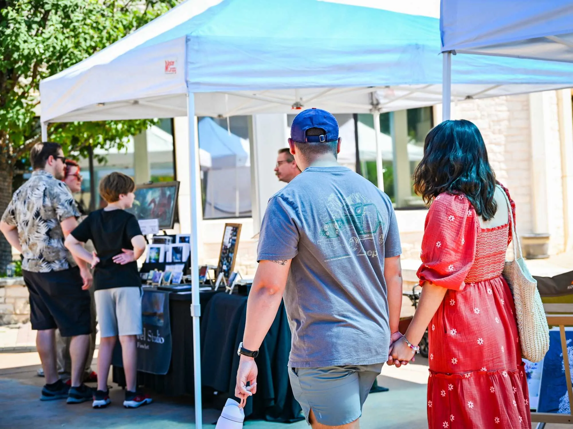 Visitors browsing an outdoor art market.