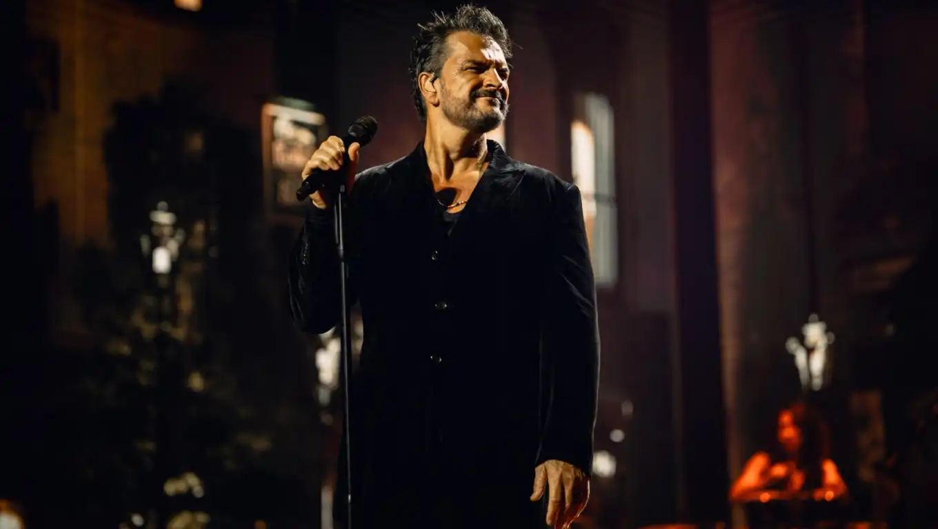 A singer performing on a dark stage.