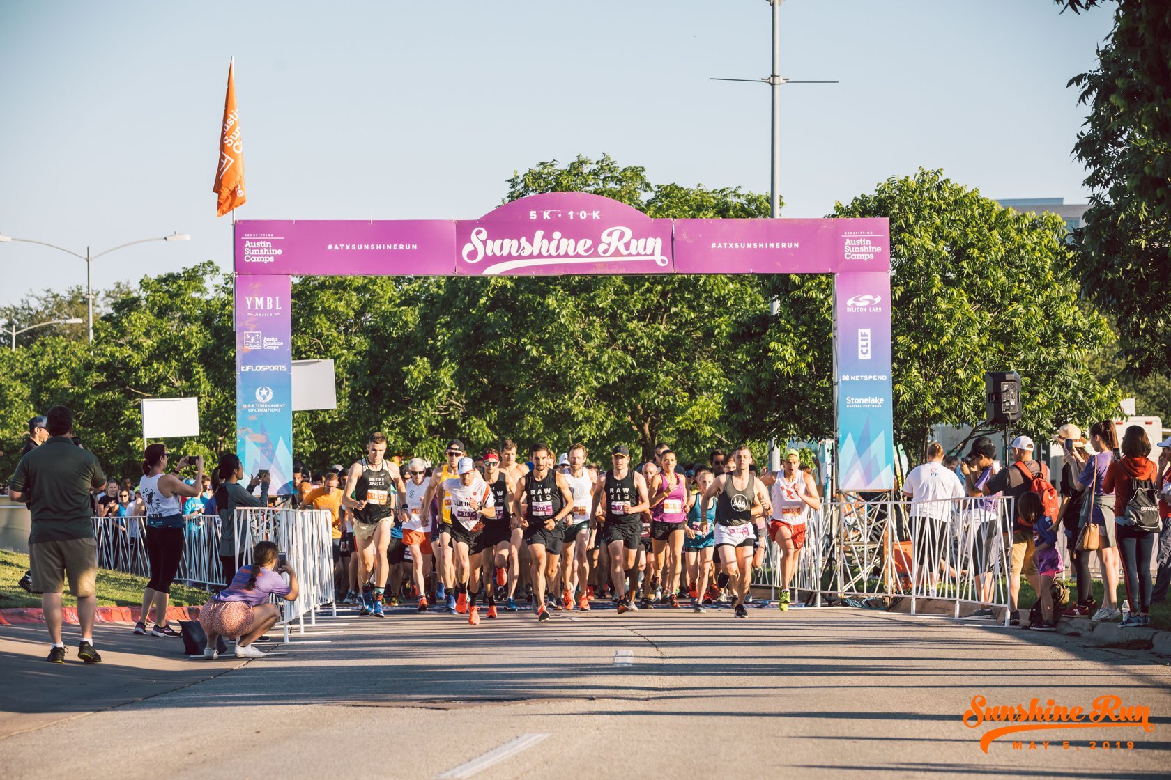 Runners beneath a race arch in an archival image marked May 5, 2019.
