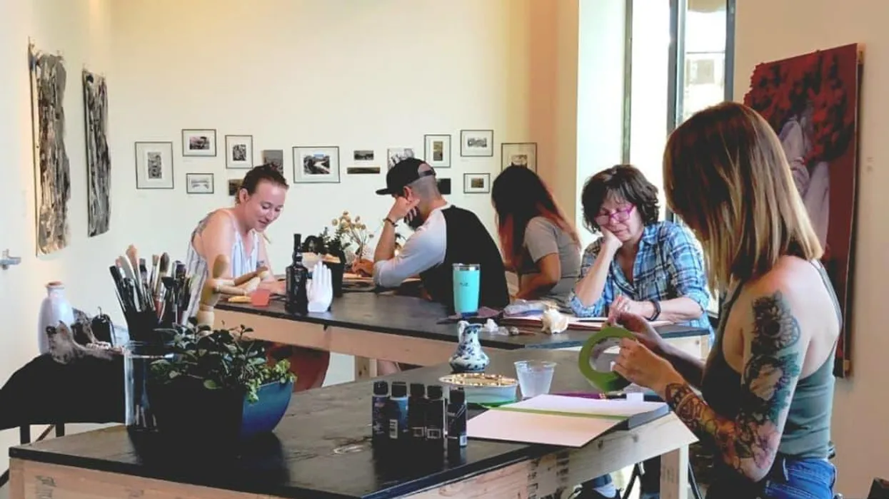 People drawing together at tables in a brewery.