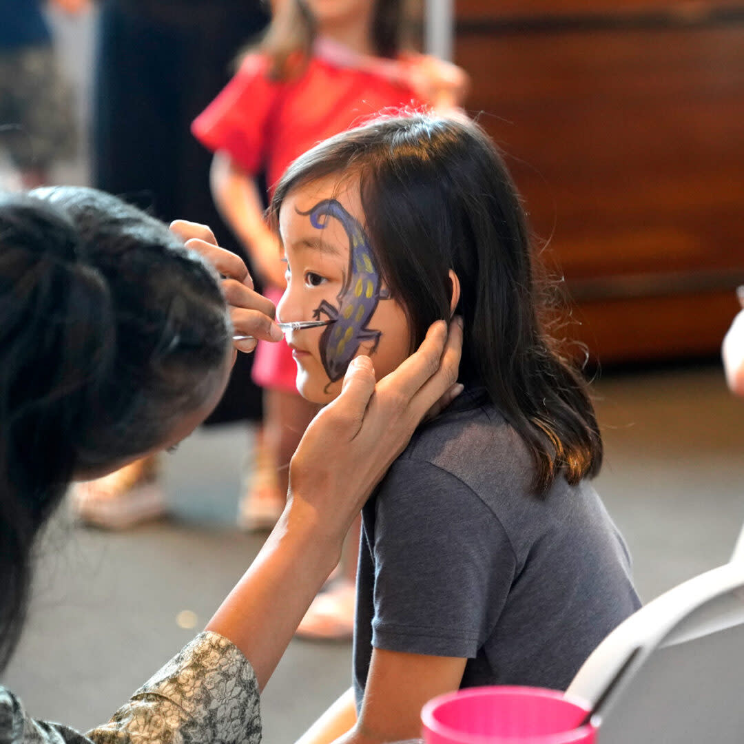 A child having their face painted.