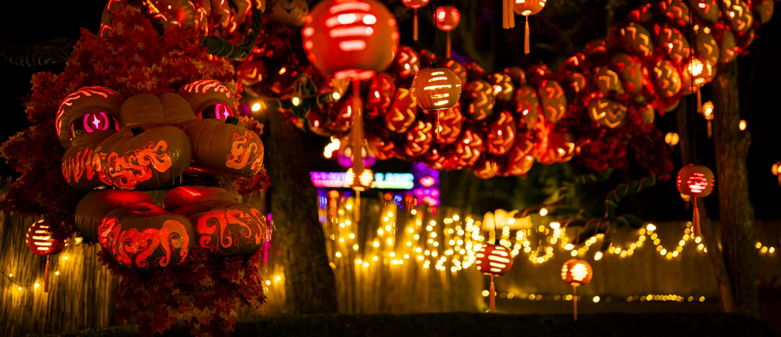 Illuminated lanterns and decorative figures along a nighttime path.