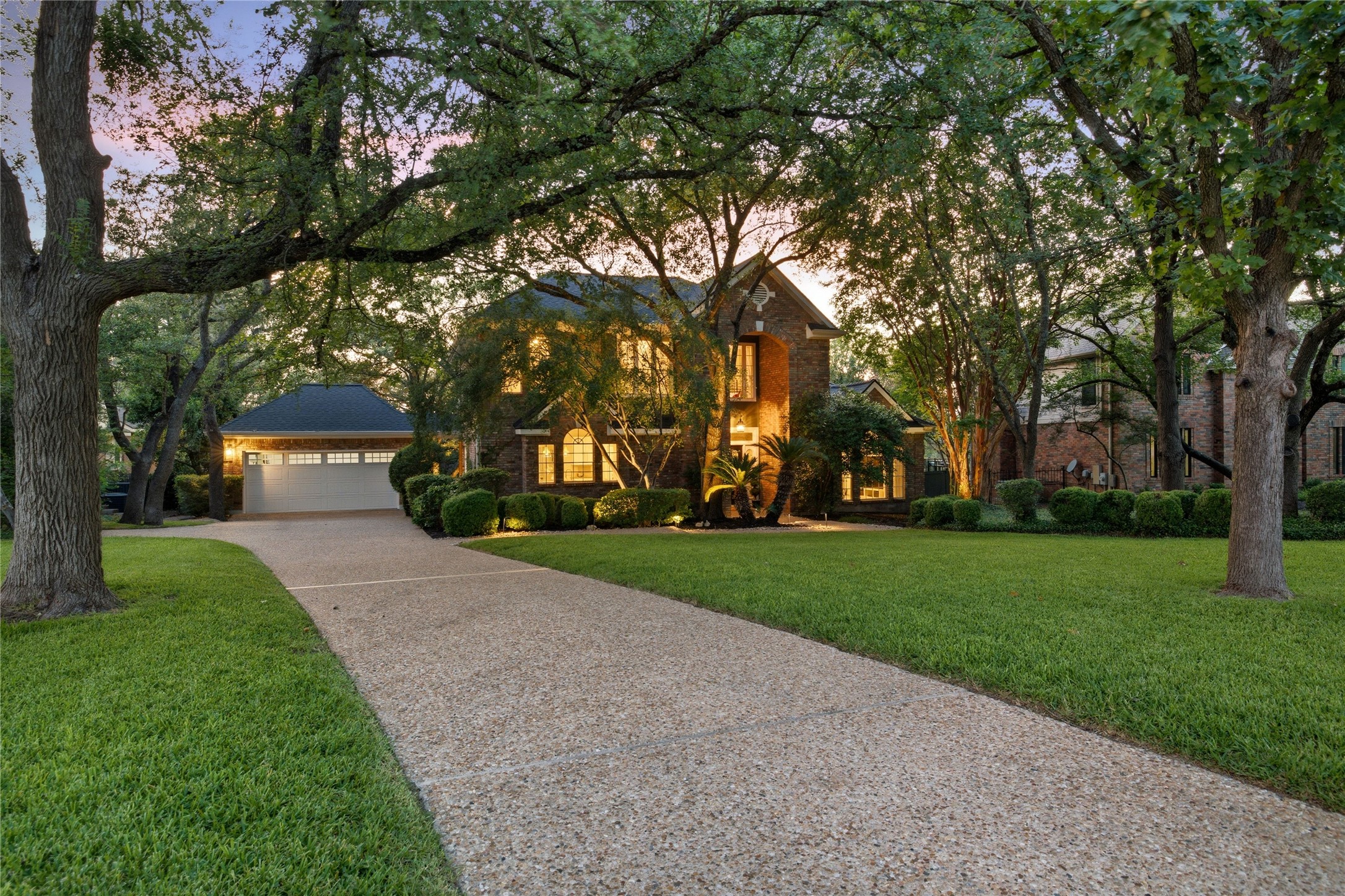 A long walkway through a shaded lawn to the brick home at 10038 Circleview Drive.