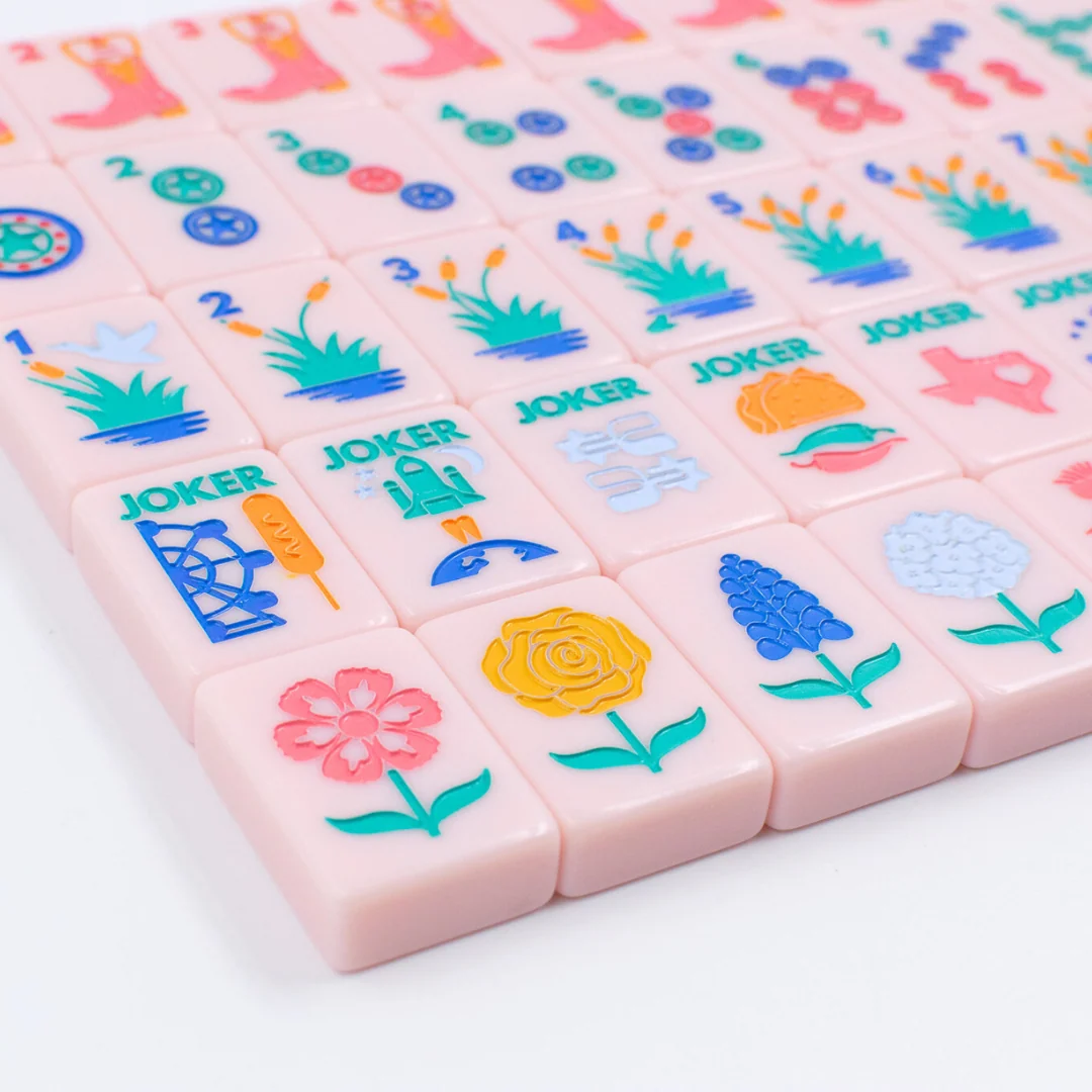 Pastel mahjong tiles printed with Texas wildflowers, laid out in rows.